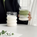Rillede drikkeglas i borosilikat med sugerør – 2 stk. Dette sæt med rillede drikkeglas i borosilikat består af to dekorative glas med en bølget form, to genanvendelige glassugerør og en rensebørste. Glassene er velegnede til servering af iskaffe, juice, mælk, iste, vand og andre kolde drikke. Den afrundede, rillede overflade giver glassene et karakteristisk udtryk og gør dem behagelige at holde omkring. Hvert glas kan bruges med det medfølgende sugerør eller som et almindeligt drikkeglas uden sugerør. Nøglefordele Sæt med to rillede drikkeglas. Fremstillet i borosilikatglas. Leveres med to genanvendelige glassugerør. Rensebørste til rengøring af sugerørene medfølger. Velegnet til iskaffe, juice, mælk, iste og vand. Bølget overflade giver glassene et karakteristisk design. Afrundet drikkekant til almindelig servering uden sugerør. Kan bruges med isterninger, frugt og andre ingredienser. Velegnet til hjemmet, kontoret og servering for gæster. Genanvendeligt alternativ til engangskrus og engangssugerør. Glassene kan bruges samlet eller hver for sig. Ingen montering eller samling nødvendig. Oversigt Disse drikkeglas med glassugerør kombinerer en praktisk drikkefunktion med en dekorativ, rilleformet konstruktion. De vandrette forhøjninger skaber en blød og afrundet silhuet, som adskiller glassene fra traditionelle glas med lige sider. Sættet indeholder to glas, så de kan anvendes til servering for to personer eller bruges på forskellige tidspunkter i løbet af dagen. Det ene glas kan eksempelvis anvendes til iskaffe, mens det andet bruges til juice, mælk eller vand. De medfølgende sugerør er fremstillet i glas og har en bøjet top, som gør dem praktiske til servering direkte fra glasset. Rensebørsten kan føres gennem sugerørene efter brug og hjælper med at fjerne rester fra kaffe, mælk, juice og andre drikkevarer. Specifikationer Produkttype Rillede drikkeglas med sugerør Antal glas 2 stk. Materiale Borosilikatglas Konstruktion Enkeltlagsglas Form Rund og bølget Håndtag Nej Antal sugerør 2 stk. Sugerørsmateriale Glas Tilbehør Rensebørste til sugerør Anvendelse Iskaffe, juice, mælk, iste, vand og andre kolde drikke Brugsområde Hjem, kontor, spisebord og servering Pakkeindhold 2 drikkeglas, 2 glassugerør og 1 rensebørste Rillet og bølget design Glassene har en overflade med flere afrundede forhøjninger, som skaber et bølget udtryk. Formen gør glassene dekorative på spisebordet, kaffebordet eller en serveringsbakke. De vandrette riller giver samtidig flere kontaktpunkter, når glasset holdes omkring midten. Det kan gøre det lettere at bevare et stabilt greb, når ydersiden er tør. Den rillede form fremhæver drikkens indhold og gør glassene velegnede til drikke med synlige lag, isterninger, mælk, kaffe, frugt eller urter. Sæt med to drikkeglas Pakken indeholder to ens drikkeglas, som kan bruges sammen eller hver for sig. Sættet passer til servering for to personer og kan anvendes ved både hverdagsmåltider og besøg. Glassene kan eksempelvis bruges til: Iskaffe til to personer. Juice ved morgenbordet. Mælk eller plantedrikke. Vand til frokost og aftensmad. Iste og andre afkølede drikke. Kolde drikke ved brunch. Servering af forskellige drikke på samme tid. Når begge glas ikke er i brug, kan det ene opbevares som reserve. Genanvendelige glassugerør Der medfølger et glassugerør til hvert drikkeglas. Sugerørene har en bøjet øvre del, som giver en praktisk drikkevinkel, når de placeres i glassene. Glassugerørene kan anvendes til: Iskaffe. Iste. Juice. Mælk og plantedrikke. Vand med frugt eller urter. Lemonade. Andre kolde drikke uden store frugtstykker. Glassugerør er beregnet til gentagen brug og kan rengøres efter hver servering. Kontrollér altid sugerøret for revner eller skår, inden det placeres i glasset. Rensebørste til sugerørene Den medfølgende rensebørste er udformet til at komme ind gennem glassugerørenes smalle åbning. Børsten hjælper med at fjerne væske og rester, som ikke altid kan skylles væk med vand alene. Rensebørsten kan bruges efter drikke med: Kaffe. Mælk. Juice. Sirup. Te. Frugt og urter. Skyl sugerørene umiddelbart efter brug, så rester ikke tørrer fast indvendigt. Til iskaffe og kolde kaffedrikke Glassene er velegnede til iskaffe med isterninger, mælk og afkølet kaffe. Glassets åbne konstruktion gør det nemt at tilføje ingredienser og røre drikken sammen. De kan blandt andet bruges til: Iskaffe med mælk. Cold brew. Afkølet espresso med isterninger. Kaffe med mælkeskum. Kolde kaffedrikke med sirup. Iskaffe med plantedrik. Tilføj først isterninger og mælk, og hæld derefter den afkølede kaffe over for at skabe synlige lag i glasset. Til juice og iste Sættet kan bruges til juice, iste og andre kolde drikke ved morgenmad, brunch eller almindelige måltider. Mulige serveringer omfatter: Appelsinjuice. Æblejuice. Frugtjuice. Iste med isterninger. Lemonade. Vand med citrusfrugt. Afkølet te med urter. Undgå meget store frugtstykker, hvis drikken indtages gennem sugerøret, da de kan blokere åbningen. Til mælk og plantedrikke Drikkeglassene kan også bruges til mælk, kakaodrikke og forskellige plantedrikke. Den rillede form giver glassene et dekorativt udtryk ved morgenbordet eller under en kaffepause. De kan eksempelvis bruges til: Mælk. Havredrik. Mandeldrik. Sojadrik. Kolde kakaodrikke. Mælk med kaffe eller sirup. Skyl glassene og sugerørene kort efter brug, så rester fra mælk og lignende drikke ikke tørrer fast. Til vand og drikke med isterninger Glassene kan anvendes som almindelige vandglas med eller uden sugerør. Den åbne top giver plads til isterninger, frugtskiver og mindre urter. Vand kan blandt andet serveres med: Isterninger. Citrusfrugt. Agurkeskiver. Bær. Mynte og andre urter. Lad lidt plads være ved kanten, så drikken ikke løber over, når isterninger eller frugt tilsættes. Borosilikatglas til gentagen brug Glassene og sugerørene er fremstillet i borosilikatglas. Materialet giver et let og enkelt drikkesæt, som kan genanvendes til mange forskellige kolde drikke. Selvom borosilikatglas er beregnet til gentagen anvendelse, skal delene stadig håndteres som almindelige glasprodukter. Hårde slag, fald og kraftigt tryk kan beskadige både glas og sugerør. Undgå at: Slå glassene mod vasken eller andet service. Presse sugerørene hårdt mod glassets bund. Bruge glassene, hvis de har revner eller skår. Udsætte glasset for pludselige temperaturskift. Placere glassene tæt på kanten af bordet. Enkeltlagsglas uden håndtag Glassene har en enkeltlagskonstruktion og er udformet uden håndtag. De løftes ved at holde omkring den midterste eller nederste del. Kondens fra kolde drikke kan gøre ydersiden fugtig. Tør derfor eventuelt glasset af, før det løftes, og brug en bordskåner for at opsamle fugt på bordet. Sættet er beregnet til almindelig servering på bordet og er ikke udformet som en lukket transportkop. Til morgenbordet og kaffepausen De to glas kan bruges ved morgenmad, brunch, frokost eller en almindelig kaffepause. De kan placeres direkte på bordet eller serveres på en bakke sammen med kande, kaffebrygger eller andre drikkevarer. Mulige placeringer omfatter: Spisebordet. Køkkenbordet. Et sidebord ved sofaen. En kaffestation. Et serveringsbord. En bakke til morgenmad eller brunch. Placér glassene på en plan og stabil overflade med passende afstand til bordets kant. Drikkeglas til kontoret Glassene kan anvendes til vand, juice eller iskaffe på kontoret og hjemmearbejdspladsen. Det genanvendelige sæt kan opbevares i et fælleskøkken eller ved en kaffestation. Ved brug på skrivebordet bør glasset stå med afstand til: Bærbar computer. Tastatur og mus. Opladere og stikdåser. Dokumenter og notesbøger. Andre genstande, som kan tage skade af væske. Brug eventuelt en bordskåner under glasset for at beskytte bordoverfladen mod kondens. Til servering for gæster Sættet med to glas er velegnet til servering ved besøg, brunch, dessert eller mindre sammenkomster. Glassene kan fyldes med samme drik eller bruges til to forskellige serveringer. De kan blandt andet anvendes ved: Morgenmad og brunch. Eftermiddagskaffe. Dessertservering. Mindre sammenkomster. Film- og spilleaftener. Servering af kolde drikke ved måltider. Glassene kan kombineres med en kande, serveringsbakke og bordskånere for at skabe en samlet servering. Sådan bruges drikkeglassene Kontrollér, at glas og sugerør er rene og uden skader. Placér glasset på en plan og stabil overflade. Tilføj eventuelt isterninger. Hæld den ønskede kolde drik i glasset. Lad lidt plads være mellem drikken og kanten. Placér glassugerøret forsigtigt i glasset. Undgå at slå sugerøret hårdt mod bunden eller kanten. Rengør alle dele efter brug. Rør drikken forsigtigt, så sugerøret ikke presses mod glassets sider. Rengøring af glassene Rengør glassene med lunkent vand, mildt opvaskemiddel og en blød svamp. Skyl dem grundigt, så alle sæberester fjernes. Følg disse trin: Fjern sugerøret fra glasset. Skyl rester fra drikken væk. Rengør indersiden med en blød svamp. Skyl glasset med rent vand. Tør det forsigtigt med et blødt viskestykke. Placér glasset stabilt under lufttørring. Undgå at anvende stor kraft omkring den rillede overflade og drikkekanten. Rengøring af glassugerørene Skyl sugerørene umiddelbart efter brug. Før derefter den medfølgende rensebørste gennem hele sugerøret. Sådan rengøres sugerørene: Skyl sugerøret med lunkent vand. Påfør lidt mildt opvaskemiddel på rensebørsten. Før børsten forsigtigt gennem sugerøret. Bevæg børsten frem og tilbage. Skyl sugerøret grundigt med rent vand. Lad det tørre stående eller liggende på et sikkert underlag. Kontrollér sugerøret efter rengøring, før det anvendes igen. Rengøring og vedligeholdelse Regelmæssig rengøring hjælper med at fjerne rester fra kaffe, mælk, juice og andre drikkevarer. Skyl delene kort efter brug, så indholdet ikke tørrer fast. Undgå at anvende: Ståluld og grove skuresvampe. Skarpe skrabere. Hårde rengøringsbørster på glassenes overflade. Kraftige opløsningsmidler. Unødvendigt stort tryk under aftørring. Redskaber, som kan ridse glasset. Kontrollér jævnligt både glas, drikkekanter og sugerør for revner eller skår. Sikker brug af glassugerør Glassugerør skal håndteres forsigtigt. Bid ikke i sugerøret, og brug det ikke, hvis der er synlige skader. Ved brug bør du: Placere sugerøret roligt i glasset. Undgå at presse det mod bunden. Undgå at slå det mod drikkekanten. Kontrollere det før hver anvendelse. Opbevare det sikkert mellem brug. Stoppe brugen ved revner eller skår. Produktet indeholder skrøbelige glasdele og bør anvendes under passende opsyn, når børn er til stede. Sikker placering Placér glassene på et stabilt underlag, hvor de ikke let kan væltes. Undgå placering tæt på kanter, hvor de kan blive ramt eller skubbet ned. Glassene bør ikke placeres direkte ved: Kanten af borde og hylder. Åben ild. Tændte kogeplader. Varme ovnlåger. Ustabile eller skrå overflader. Områder med risiko for hårde slag. Brug ikke glas eller sugerør, som har været tabt, uden først at kontrollere dem grundigt for skader. Opbevaring mellem brug Alle dele skal være rene og tørre før opbevaring. Glassene kan opbevares stående i et skab eller på en stabil hylde. Sugerørene kan opbevares: Liggende i en skuffe med passende beskyttelse. Stående i en beholder. Sammen med andet genanvendeligt drikketilbehør. På et sted, hvor de ikke kan rulle ned. Undgå at placere tunge genstande oven på glassene eller sugerørene. Pakkeindhold 2 rillede drikkeglas i borosilikatglas. 2 genanvendelige glassugerør. 1 rensebørste til sugerørene. Drikkevarer, isterninger, frugt, bordskånere og øvrige viste serveringsgenstande medfølger ikke. Rillede drikkeglas til iskaffe, juice og mælk Dette sæt med to rillede drikkeglas i borosilikat giver en dekorativ og genanvendelig løsning til servering af iskaffe, juice, mælk, iste, vand og andre kolde drikke. Der medfølger to bøjede glassugerør og en rensebørste, så sugerørene kan rengøres efter brug. Den bølgede form giver glassene et karakteristisk udtryk og gør sættet velegnet til både daglig brug, kontoret og servering for gæster.