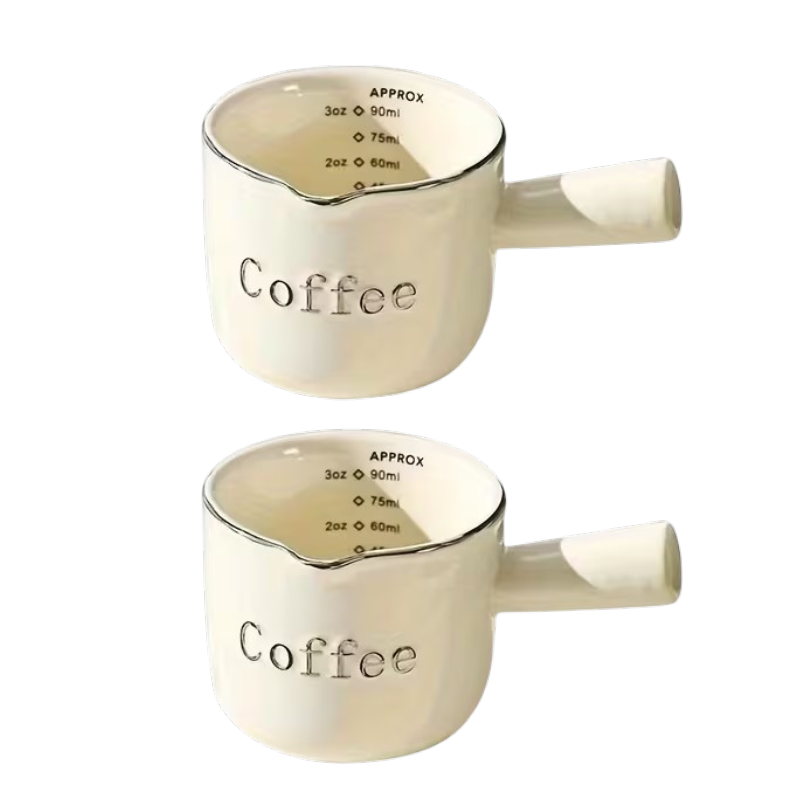 7eae6791d164dfc6189b554129097f90 To keramiske målebægre med håndtag, hældetud og indvendig skala til espresso, mælk, honning og sauce