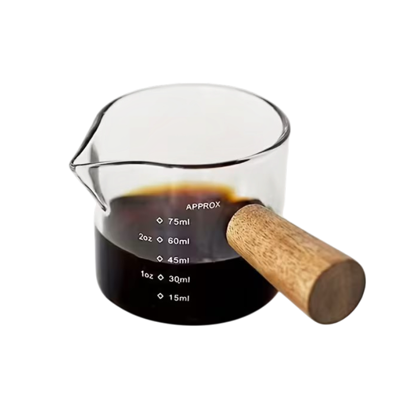 a435d8b7-c7b1-4694-bfa9-30553e1a2500 Varmebestandigt målebæger i glas med træhåndtag, måleskala og hældetud til espresso, mælk, sirup og sauce